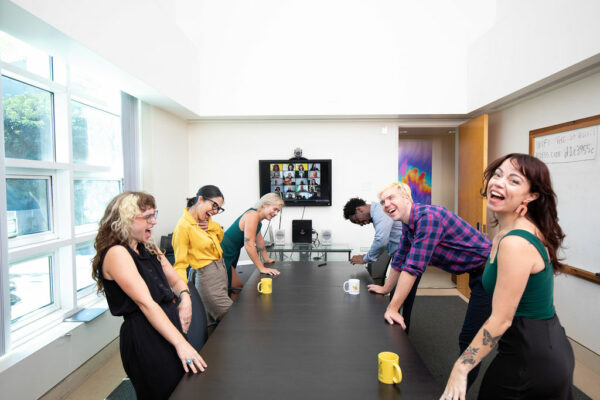 A team laughing together around a conference table at a Social Someone corporate event